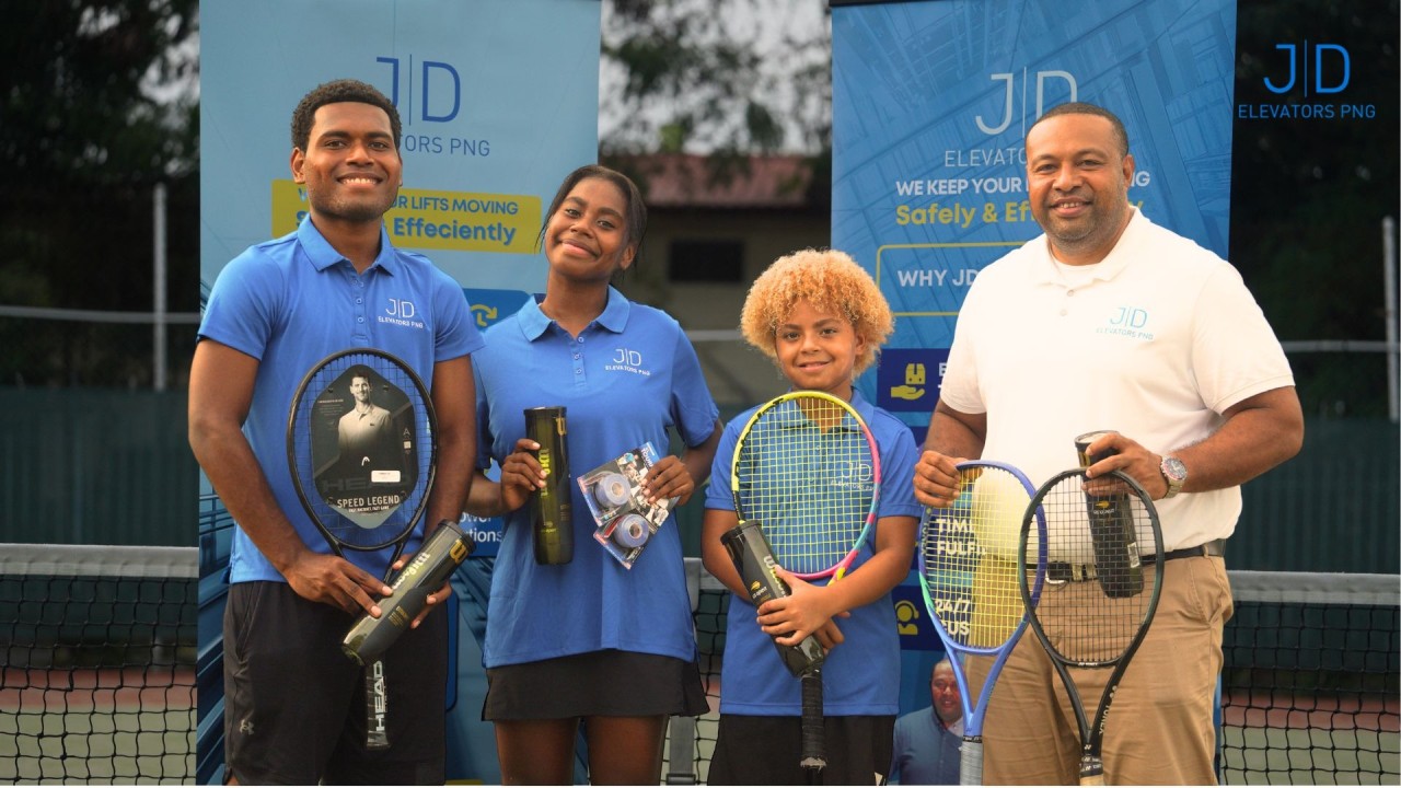 From right: Lawrence Lahari (JD Elevators PNG Business Development Manager) stands proudly with rising tennis stars River-Jordan, Colita, and Sugar Ra